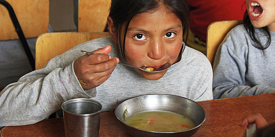strassenkind aus ecuador isst suppe